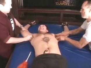 Two older guys having fun tickling a tied up younger dude